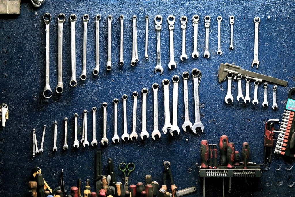 Plusieurs types d'outils rangé sur un mur bleu